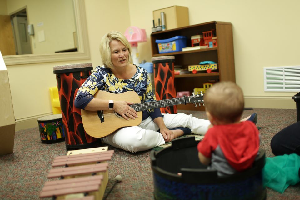 WVU Music Therapist plays guitar with client